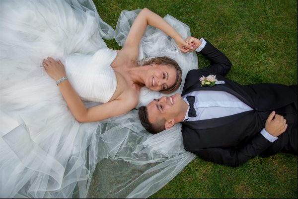 HochzeitsfotografInnen in Wien braut und bräutigam posieren auf gras
