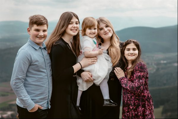 Glückliche Geschwister stehen zusammen für ein Foto im Naturpark Hohe Wand, Österreich Glückliche Geschwister stehen zusammen für ein Foto im Naturpark Hohe Wand, Österreich