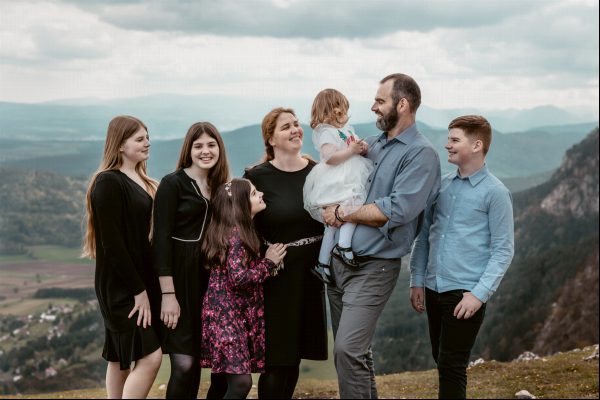 Eine glückliche Familie bereitet sich darauf vor, ihr Foto in den österreichischen Alpen zu machen.