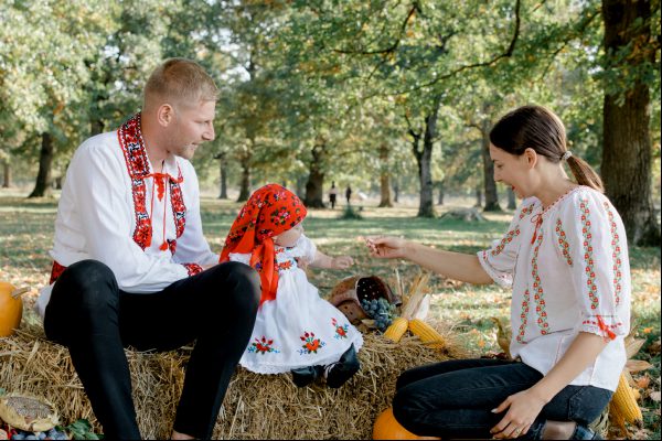Mama , tata si fetita imbracati in port traditional romanesc la o sedinta foto de toamna