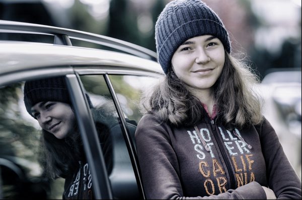 Sweet sixteen photo session, reflexion in the side window of a car