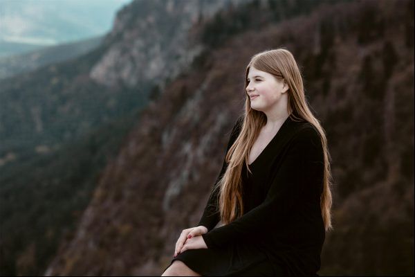 Mit Blick auf den Naturpark Hohe Wand sitzt eine junge Frau auf einem Felsen und nimmt sich einen Moment Zeit, um zu spüren, wie die Bergluft ihren Geist klärt. Mit Blick auf den Naturpark Hohe Wand sitzt eine junge Frau auf einem Felsen und nimmt sich einen Moment Zeit, um zu spüren, wie die Bergluft ihren Geist klärt.