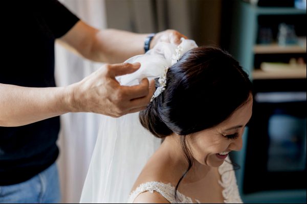 Braut macht sich im Bassena Hotel fertig Einer Braut wird der Schleier aufgesetzt