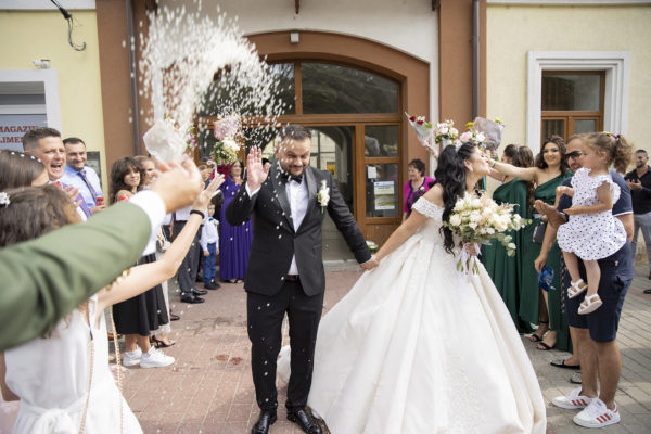 groom and bride welcomed by throwing rise all over them